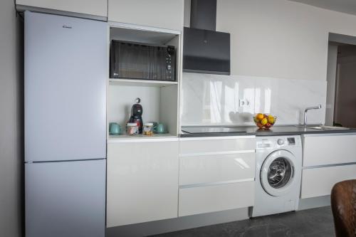 a kitchen with white cabinets and a washer and dryer at Apartamento Suite 48- Recién reformado in Avilés