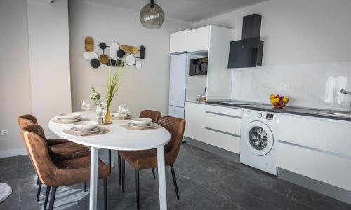 a kitchen with a white table and chairs in a kitchen at Apartamento Suite 48- Recién reformado in Avilés
