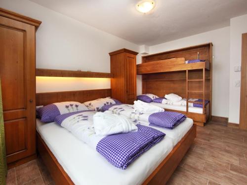 2 camas en una habitación con almohadas moradas y blancas en Chalet Vorderjausern en Saalbach Hinterglemm
