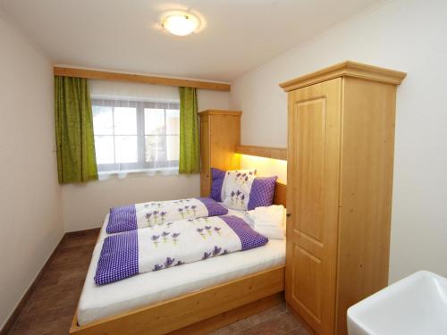 a small bedroom with a bed and a window at Zirmblick in Saalbach-Hinterglemm