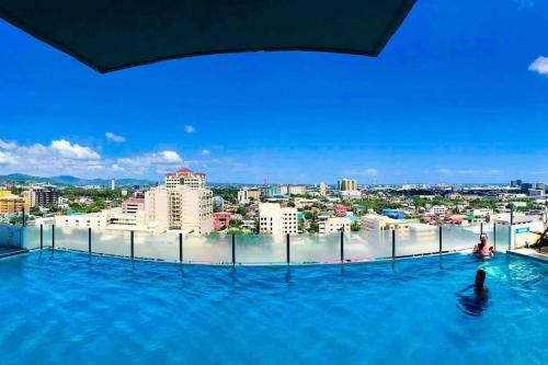 Una persona en una piscina infinita con vista a una ciudad. en Chillhauz (SM,Ayala,IT,City) W/Pool & WiFi, en Cebú