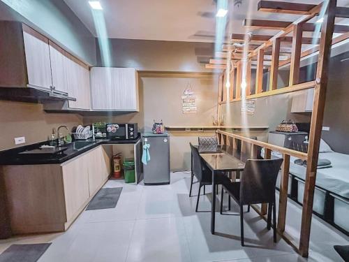cocina grande con mesa y nevera en Chillhauz (SM,Ayala,IT,City) W/Pool & WiFi, en Cebú