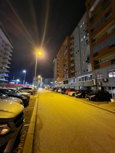 a parking lot with cars parked on a street at night at Greta apartment in Podgorica