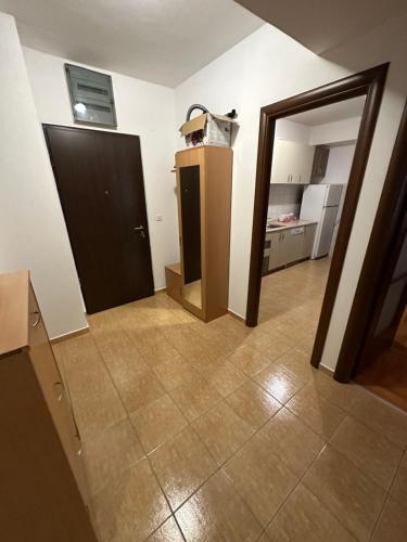 an empty room with a door and a kitchen at Greta apartment in Podgorica