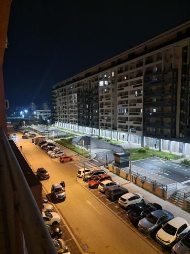 a parking lot with cars parked in front of a building at Greta apartment in Podgorica