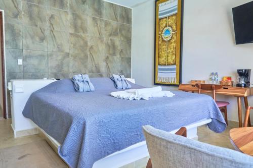a bedroom with a blue bed with towels on it at Hotel Casa Justina in Puerto Ángel