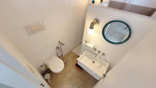 y baño con aseo blanco y espejo. en Barolo+ Seu Loft em BsAs en Buenos Aires