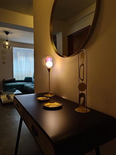 a living room with a table with a lamp and a mirror at Apartamento Suite 48- Recién reformado in Avilés
