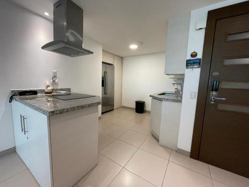 a kitchen with white cabinets and a counter top at Departamento en Manta Edificio Poseidon in Manta