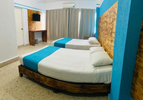 2 camas en una habitación de color azul y blanco en Hotel Lu Acapulco en Acapulco