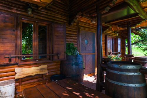 a wooden cabin with a table and two barrels at Wine & Relax Sveti Martin na Muri in Gornji Koncovčak