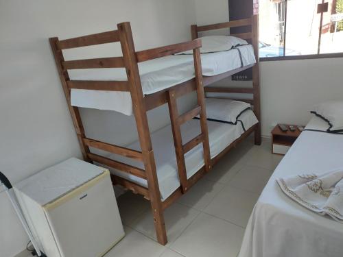 a room with two bunk beds and a refrigerator at Pousada Recanto Paraíso Família in Caldas Novas