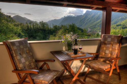 a table and two chairs on a balcony with a view at Tourist Farm Kranjc in Kobarid