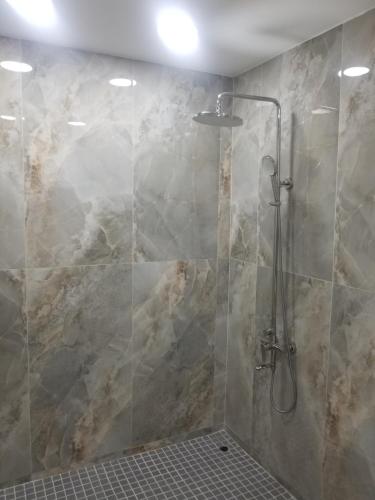 La salle de bains est pourvue d'une douche avec une porte en verre. dans l'établissement Classical accommodation, à Calliste Land Settlement