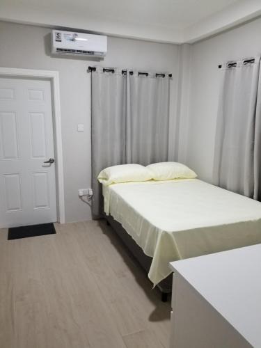 - une chambre avec 2 lits et une porte blanche dans l'établissement Classical accommodation, à Calliste Land Settlement