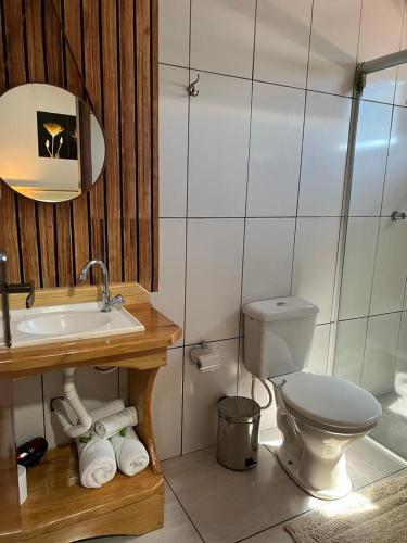 a bathroom with a sink and a toilet in it at Pousada Serra Geral in Cambará