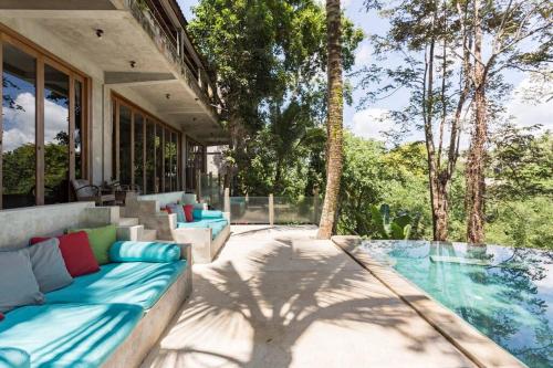 an outdoor patio with a couch and a pool at RiverView Gardens in Ubud