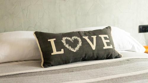 a pillow with the word love written on it on a bed at relax hotelito in Cárdenas