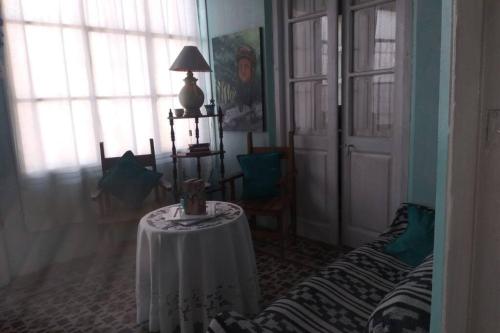una sala de estar con una mesa con una lámpara. en La Casona, chalet rural en finca con piscina JUNÍN DE MENDOZA en Junín