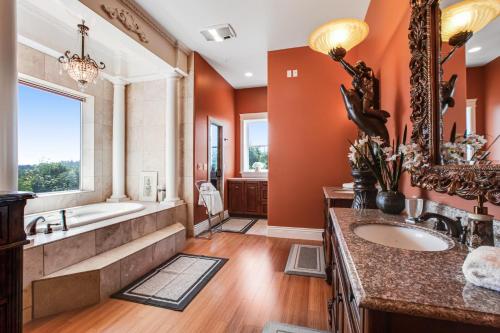 uma casa de banho com paredes cor-de-laranja, uma banheira e um lavatório. em Castle on the Hill em Maple Grove Beach