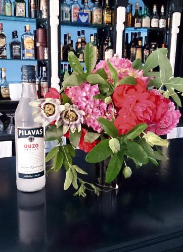 a bottle of wine sitting next to a bouquet of flowers at Hotel Elena Ermones in Ermones
