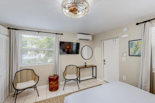 een slaapkamer met 2 stoelen, een bed en een raam bij Tiki Room in Marathon
