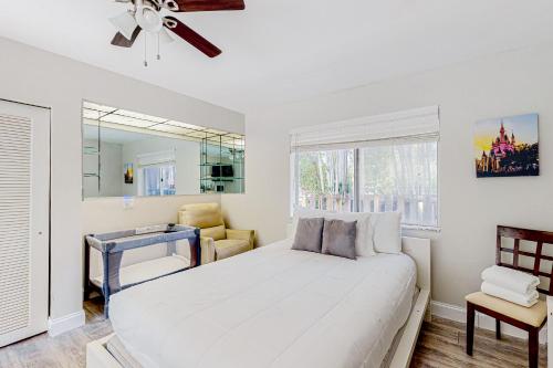 - une chambre blanche avec un lit et une chaise dans l'établissement Sunny Oasis, à Hollywood