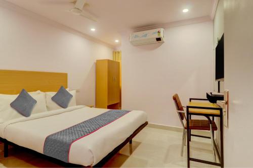 a bedroom with a bed and a table and a desk at Townhouse Rcc Premier Sr Nagar in Hyderabad