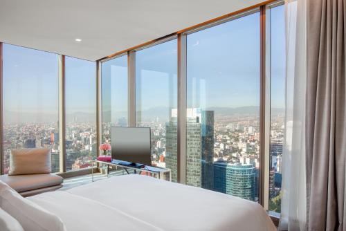 a bedroom with a large bed and glass windows at Sofitel Mexico City Reforma in Mexico City