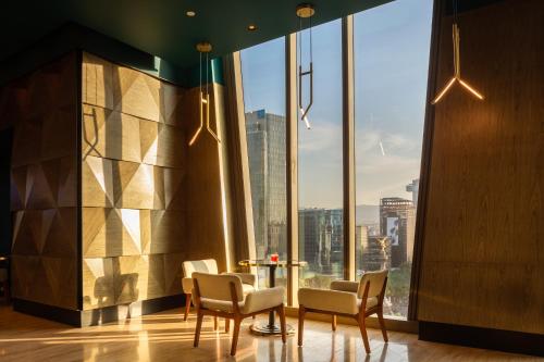 a room with a table and chairs and a large window at Sofitel Mexico City Reforma in Mexico City