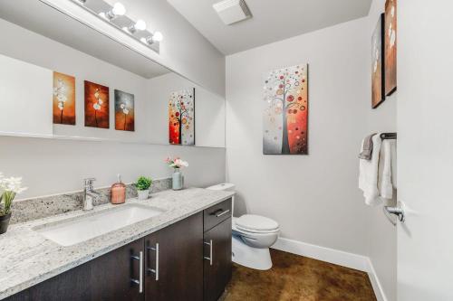 a bathroom with a sink and a toilet at Upscale 2BR Condo - King Bed - Stunning Views in Calgary