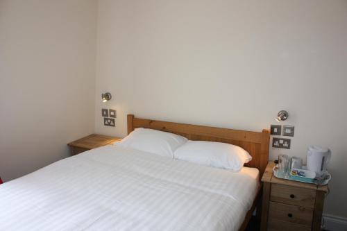 a bedroom with a white bed and two night stands at Earls Court Garden Hotel in London