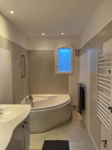 une salle de bain avec une baignoire, un lavabo et une fenêtre dans l'établissement La Bastide du Bas Peylon - Un havre de paix dans un écrin de verdure, à Flayosc