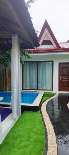 a house with a swimming pool in the yard at Carpe Diem Villas & Resort in Puerto Princesa City