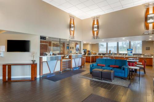 a large lobby with a blue couch and a bar at Comfort Inn & Suites Redwood Country in Fortuna