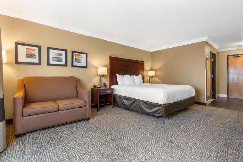 a hotel room with a bed and a chair at Comfort Inn & Suites Redwood Country in Fortuna