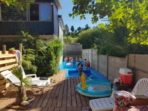 a backyard with two pools with people playing in them at Hostal de Luz in Villarrica