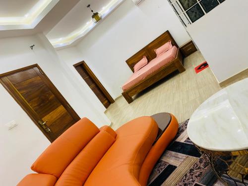 an orange couch in a living room with a table at Résidence El Hadji Annexe in Dakar
