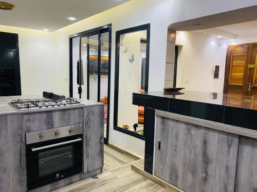 a kitchen with a stove and a counter top at Résidence El Hadji Annexe in Dakar