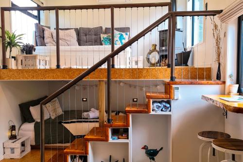 a room with a bunk bed in a loft at Adventurer's Chest - Pohutukawa in Hotwater Beach