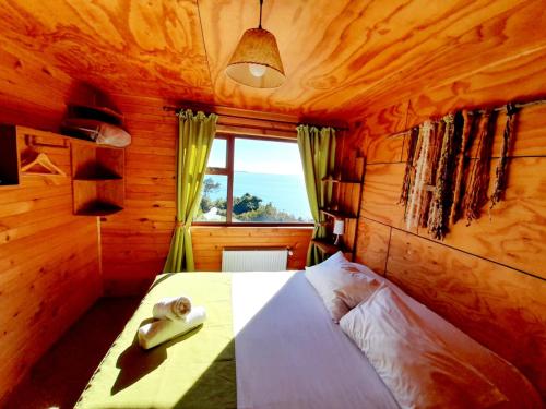 Dormitorio pequeño con cama y ventana en Hotel y Cabañas Terrazas Vista al Mar hct, en Ancud