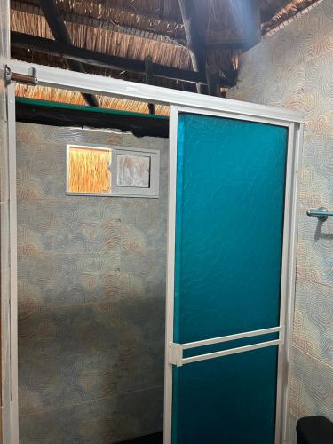 niebieskie drzwi w pokoju ze ścianą w obiekcie Eco Hostal Villa Canada - A Sustainable Oasis on Isla de Tierra Bomba w mieście Playa Punta Arena