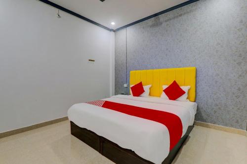 a bedroom with a bed with a red and yellow headboard at OYO Flagship Ideal Inn in Lucknow