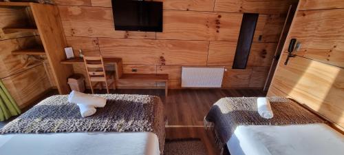 a room with two beds and a television in it at Hotel y Cabañas Terrazas Vista al Mar hct in Ancud