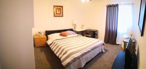 a bedroom with a bed and a desk and a window at Entire cozy home in Madera