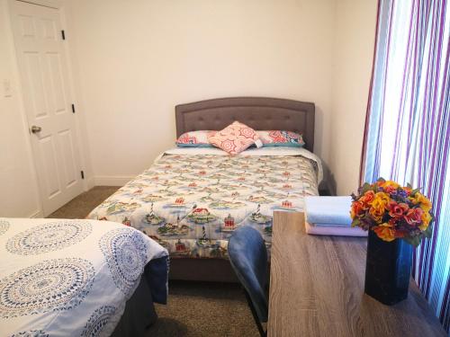 a bedroom with a bed and a table with flowers on it at Entire cozy home in Madera