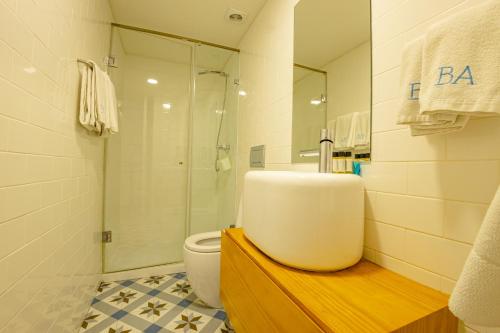 a bathroom with a sink and a toilet and a shower at Belas Artes Apartments in Porto
