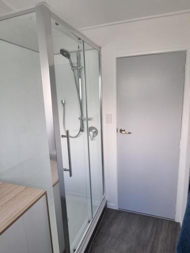a shower with a glass door in a bathroom at Linden Lodge Haven in Wellington