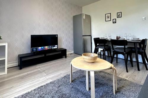 a living room with a table and a television at Stunning 2-bed apt near central London. in London
