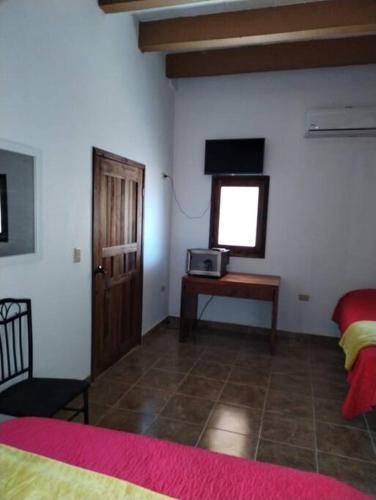 - une chambre avec un lit, une télévision et une table dans l'établissement Carmen Graciela, à Álamos